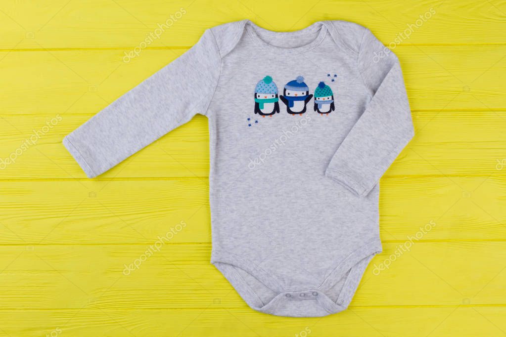 White cotton infant creeper with image. Cute image with penguins on infant creeper.