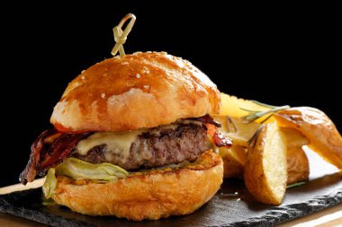 Pastırmalı çizburger, marul ve patates cipsi.