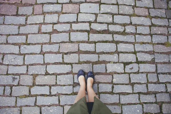 female legs on paving stone