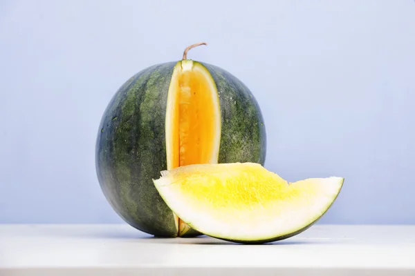 Gula vattenmelon på blå bakgrund — Stockfoto