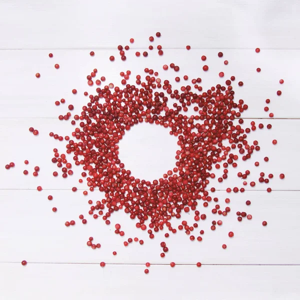 Кругла рамка червоної журавлини на білому дерев'яному фоні — стокове фото