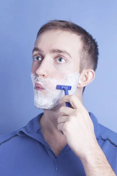 Handsome young man shaving — Stock Photo, Image