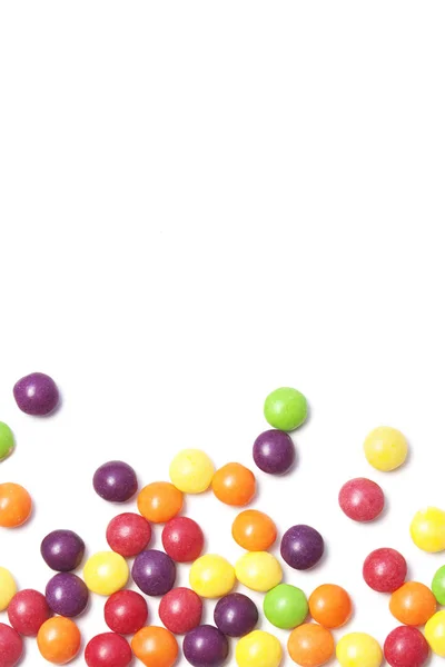 Fundal alb cu bomboane colorate rotunjite pe partea de jos — Fotografie, imagine de stoc