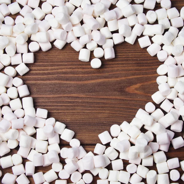 Ram i form av hjärta av marshmallow på trä bakgrund. — Stockfoto