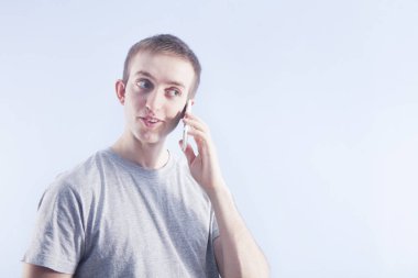 Telefon görüşmesi. Kulak yakınındaki smartphone ile genç adam. 