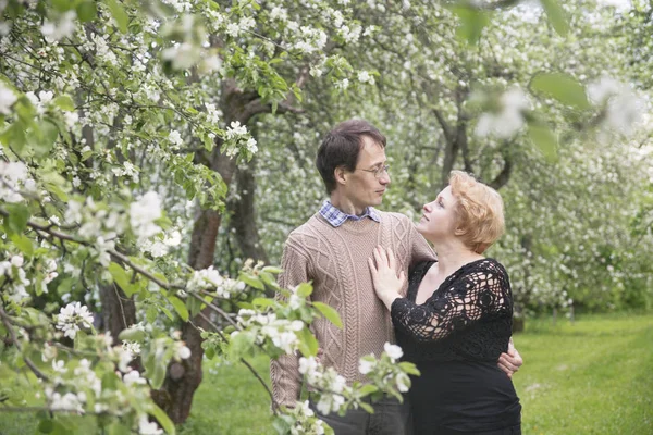 Liebendes Ehepaar im blühenden Apfelbaumgarten. — Stockfoto