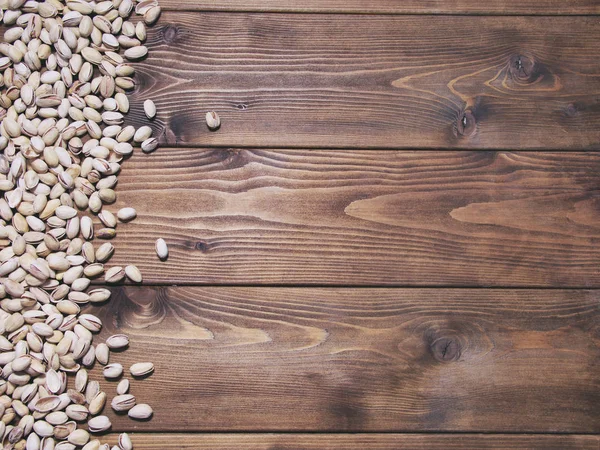 Tuzlu fıstık ahşap arka plan üzerinde. Gıda