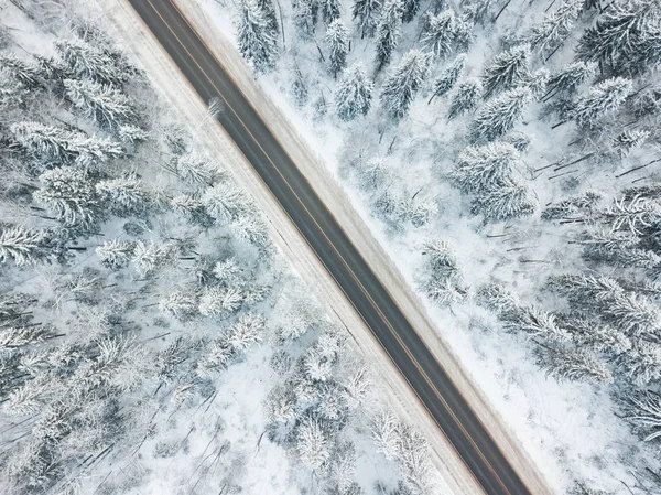 Route à travers la forêt. Vue aérienne paysage hivernal — Photo