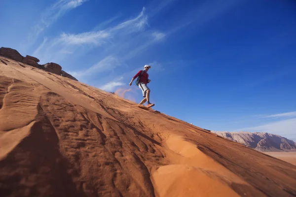 Człowiek działa w dół wydmy pustyni Wadi Rum, Jordania — Zdjęcie stockowe