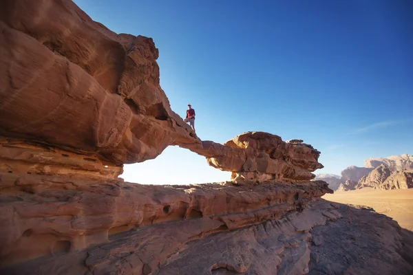 Turista en roca. El desierto de Wadi Ram. Puente de piedra. Jordania paisaje — Foto de Stock