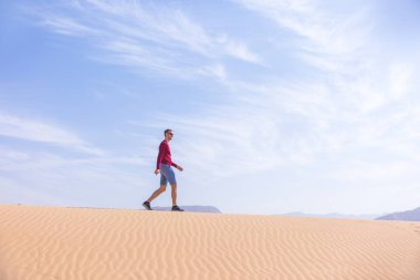 Turist Wadi Araba çöl, kumul üzerinde Jordan yürür.