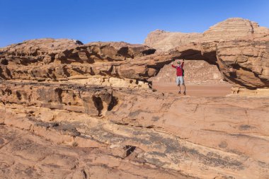 Turist kayanın üzerine. Wadi Ram çöl. Taş köprü. Jordan manzara