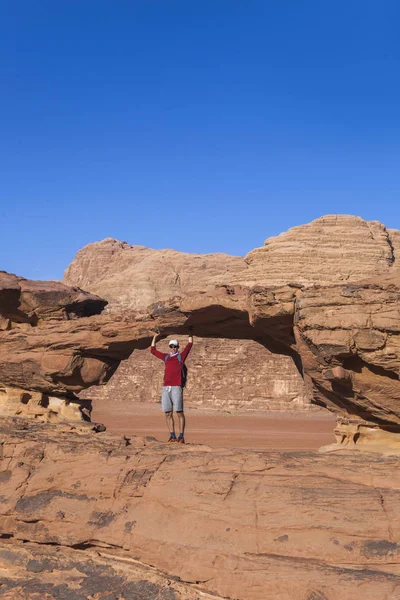 Turista em pedra. Deserto de Wadi Ram. Ponte de pedra. Jordânia paisagem — Fotografia de Stock