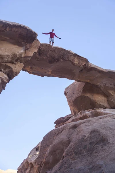 Turista em pedra. Deserto de Wadi Ram. Ponte de pedra. Jordânia paisagem — Fotografia de Stock