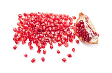 Beyaz bir zemin üzerinde tohumlar olan bir parça nar.