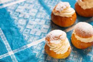 Retro pamuk masa örtüsü üzerinde taze semla (Estonya 'da vastlakukkel). Salı veya ilgili günlerde İskandinav ve Baltık ülkelerinde krem şantili geleneksel tatlı çörek