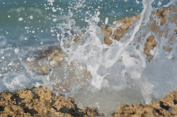 Ola de mar se rompe por las piedras costeras — Foto de Stock