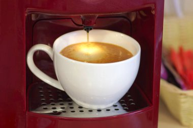 Beyaz fincan sade kahve kahverengi cappu ile bir kahve makinesi ile