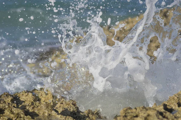 Ola de mar se rompe por las piedras costeras — Foto de Stock