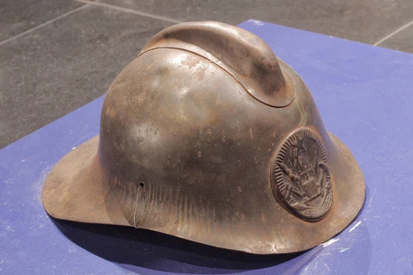 Old fire helmet protects the head of a fire extinguisher — Stock Photo, Image