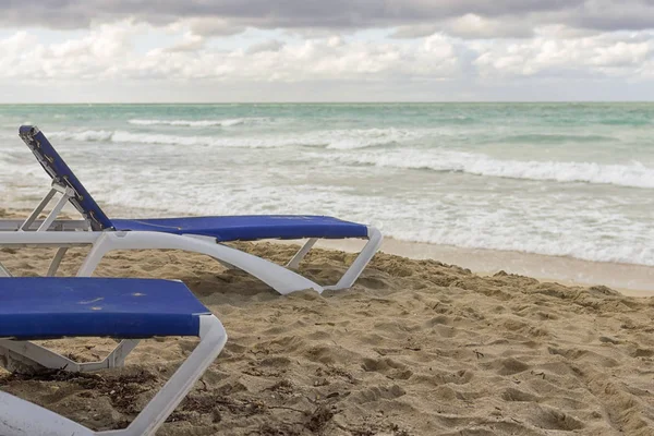 Chaise salones vacíos en el fondo de un mar desierto, el en — Foto de Stock