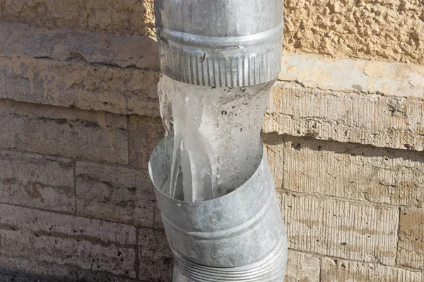 Iced icicles from a burst pipe for a drain — Stock Photo, Image