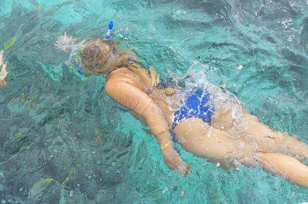 Chica buceadora en aletas y máscara con un tubo flotando en la superficie — Foto de Stock