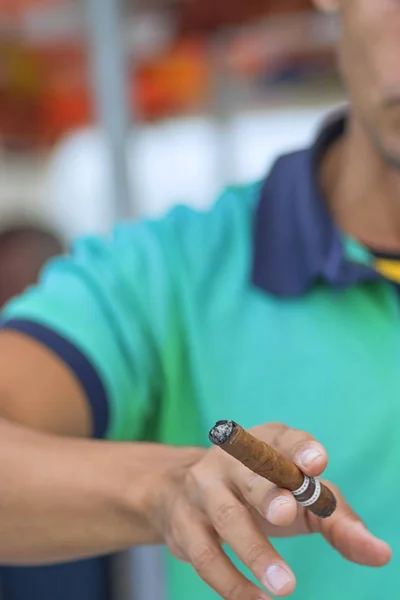 Cigarrillo cubano en la mano de un hombre contra una camisa ligera — Foto de Stock