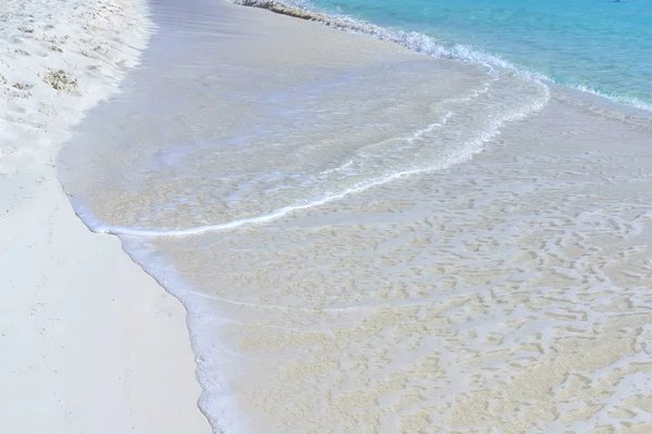 海波与泡沫跑到沙地岸边, 冲走 footp — 图库照片