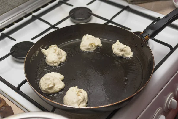 Pezzi di pasta in olio bollente in padella, frittelle di cottura — Foto Stock