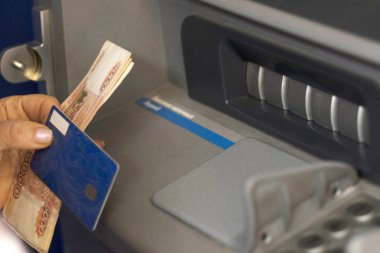 El banka kartı ve nakit ATM önünde tutar