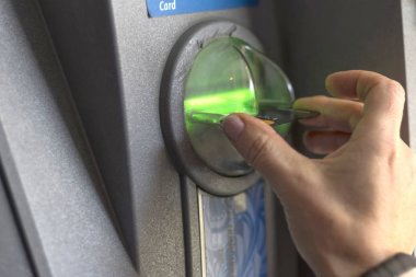 El, ATM alıcısına bir banka kartı ekler