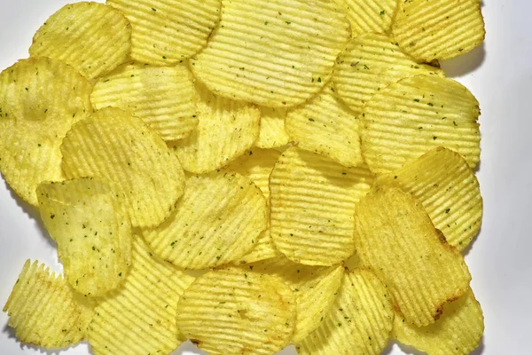 Batatas fritas onduladas com cebola verde em um fundo branco , — Fotografia de Stock