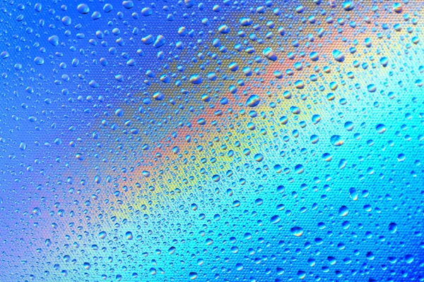 Drops on the glass against the background of the rainbow, textur — Stock Photo, Image