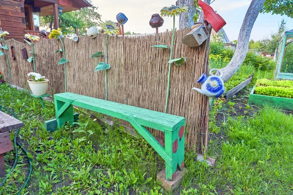Деревенский забор из веток с различной бытовой утварью — стоковое фото