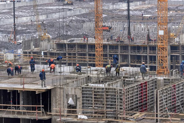 Muchos constructores en cascos y máscaras en el último piso de un hou — Foto de Stock