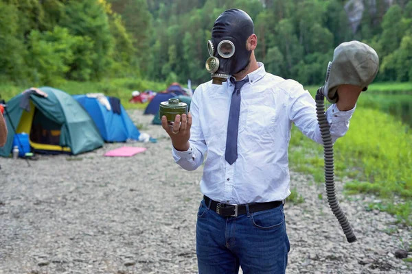 A man in a gas mask holding a carbon filter. Environmental problems and environmental pollution