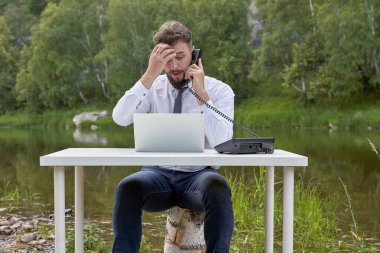 Genç işadamı, parkta gölde ofis telefonuyla konuşurken alnını kaşıyordu. Dünyanın herhangi bir yerinden destek