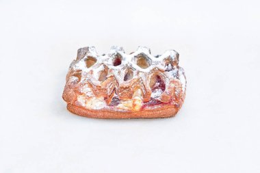 Kırmızı böğürtlen reçeli ile doldurulmuş dikdörtgen pudra şekerli börek. Fırın çeşitleri fırınından yemek. Işık arkaplanına yakın plan