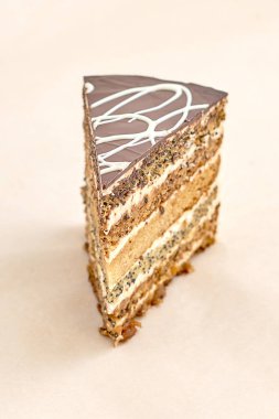 Üstünde krema ve çikolata kremalı lezzetli bir parça kek. Taze hamur işleri, çeşitli fırınlar ve fırınlar. Hafif bir arkaplanda yakın plan. Dikey çerçeve