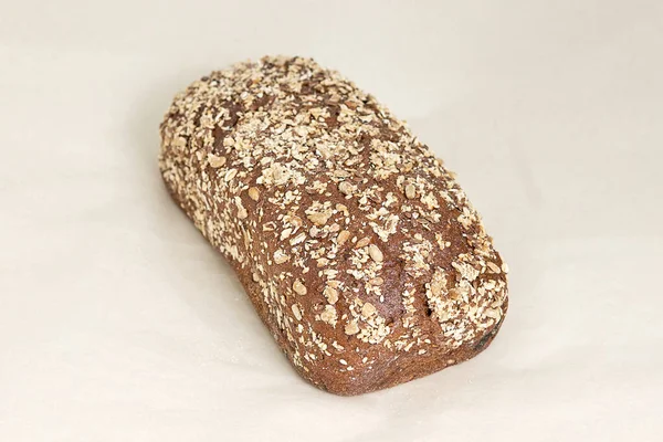 新鲜的褐色面包 用黑麦粉配上切碎的杏仁 新鲜的糕点 各种烘焙和糖果制品 浅色背景上的遮挡 镜框中的对角线位置 — 图库照片