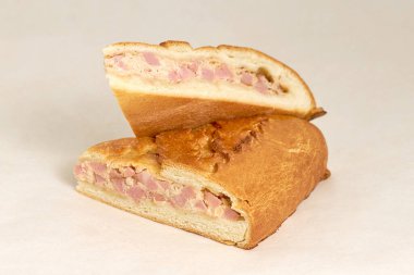 Jambon ve peynirle doldurulmuş turta. Taze hamur işleri. Hafif bir arkaplanda yakın plan. Lezzetli ve sağlıklı fırın ve pastane