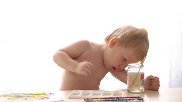 The child draws the hands of an adult changed the water for washing brushes — Stock Video