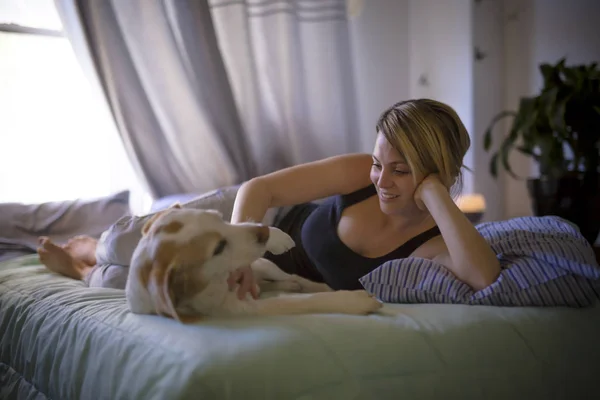 Frau mit Hund zu Hause im Bett — Stockfoto