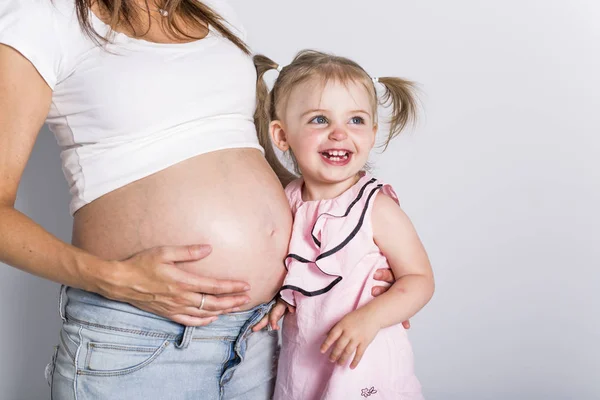 Młoda dziewczyna z kobieta w ciąży na białym tle — Zdjęcie stockowe