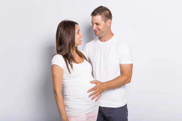 Casal caucasiano esperando bebê sorrindo alegre no branco — Fotografia de Stock