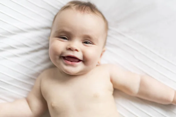 Bonito feliz 7 meses bebê menina na fralda mentindo e jogando — Fotografia de Stock