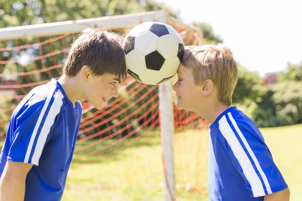 Deux jeunes garçons avec un ballon de football sur un uniforme de sport — Photo