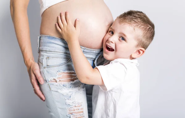 Kleiner Junge mit der schwangeren Frau isoliert auf weißem Hintergrund — Stockfoto