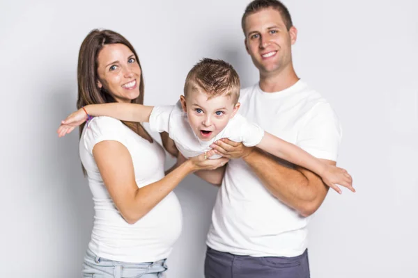 Gelukkige ouders vliegtuig spelen met hun kind jongen geïsoleerd op witte achtergrond — Stockfoto